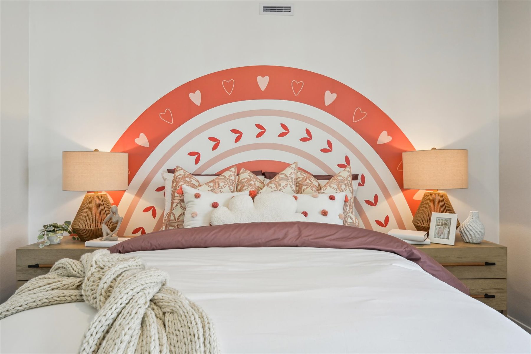 A bed with a pink and white bed spread.